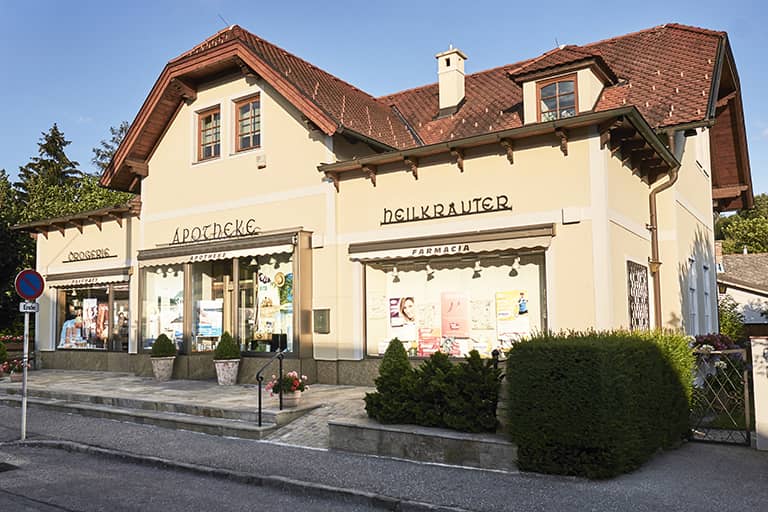 Aussenansicht der Apotheke zur heiligen Dreifaltigkeit Pressbaum im Sommer.